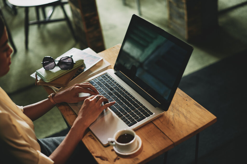 Woman working on laptop when sitting in cafe, view from above